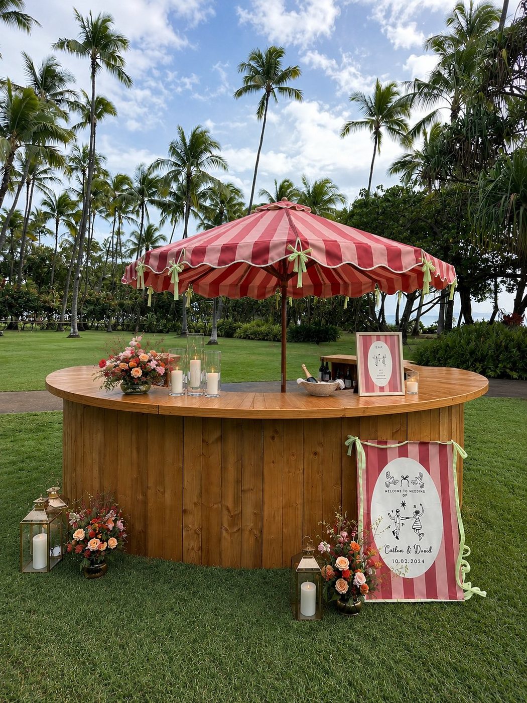 Light wood semi-circle bar with pink striped Amalfi-style umbrella, florals, and lanterns at a tropical wedding