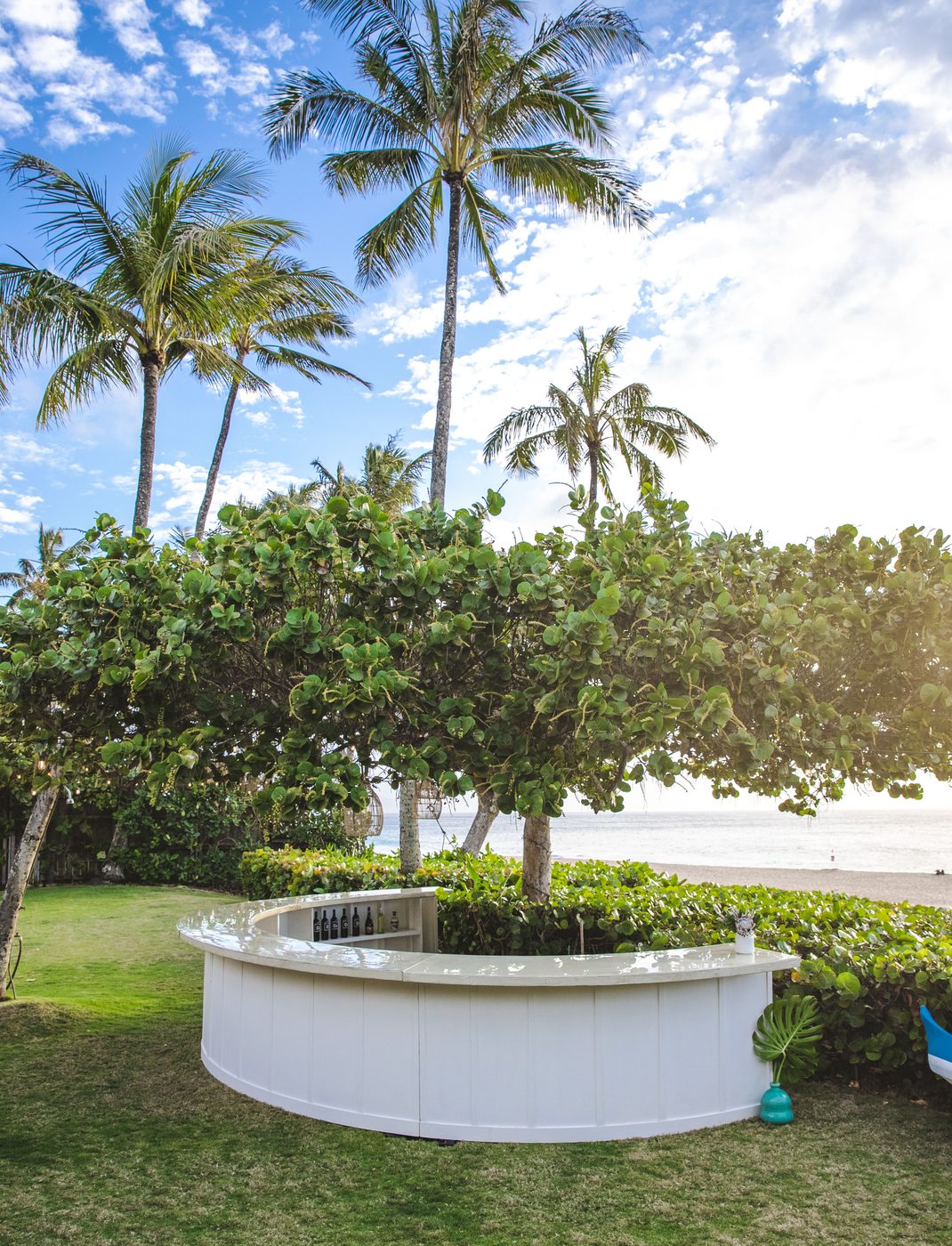 White semi-circle bar set against the ocean on Oahu's North Shore with palm trees